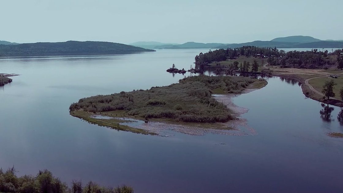A lake with a green peninsula and an island in Nadleh