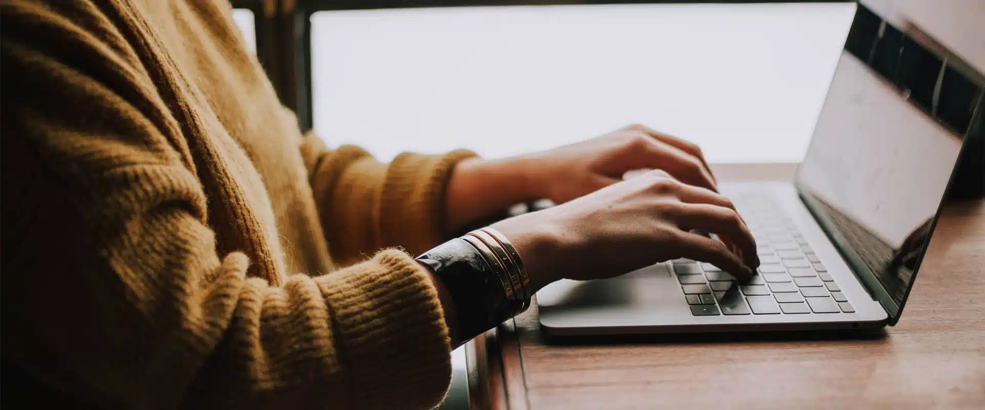 hands typing on a laptop