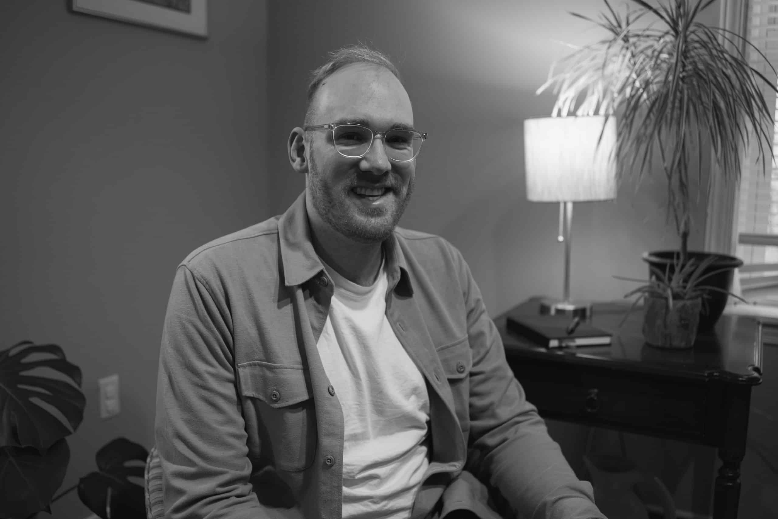 Joshua Reinders, author of Friendship Matters in Fatherhood sits on a chair in an office